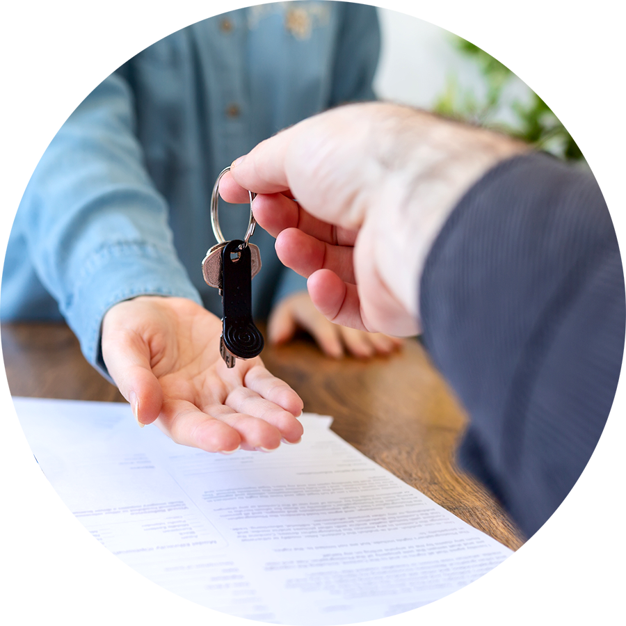 Handing over house keys after a home inspection and signing insurance documents